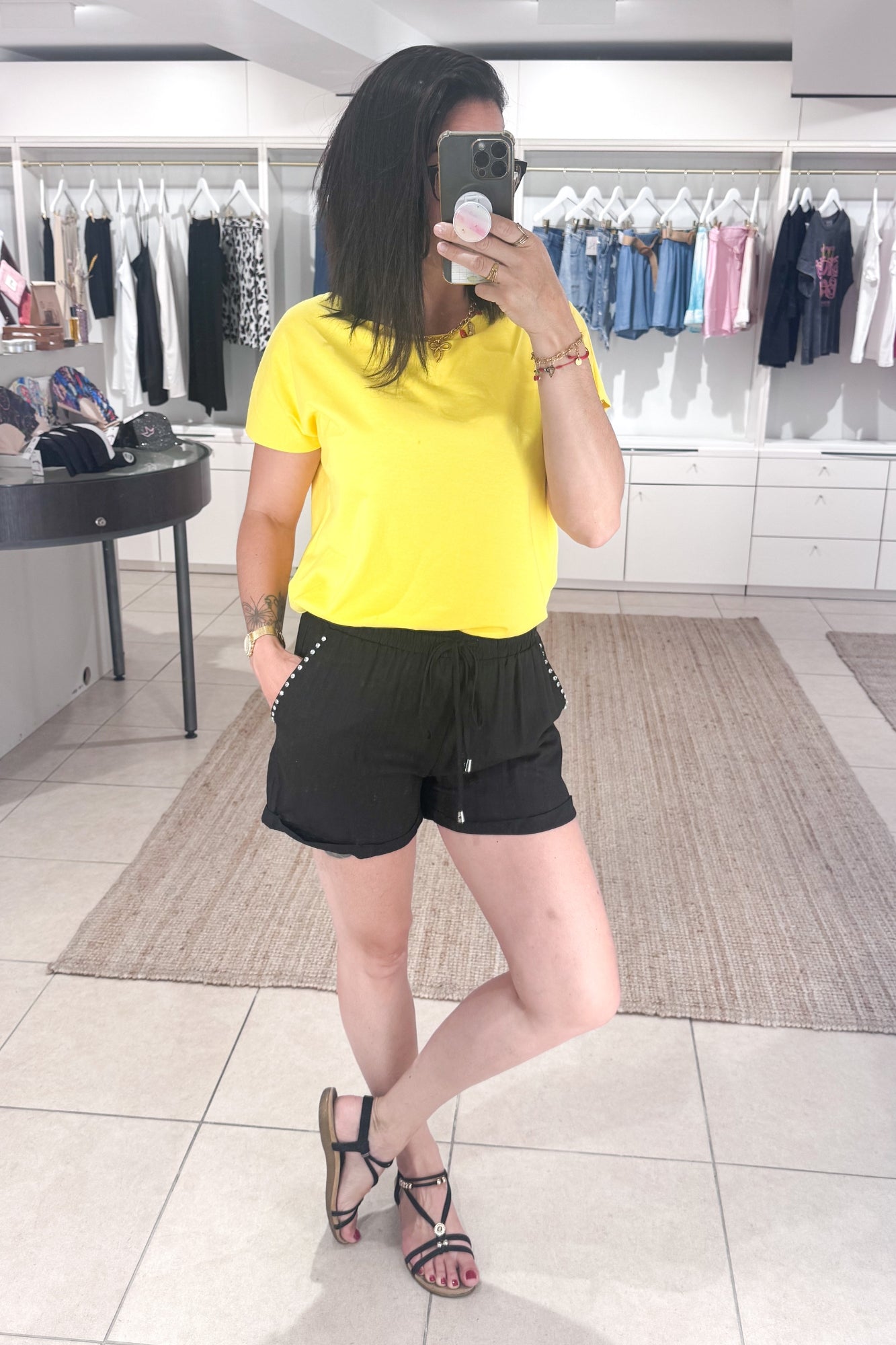 Short noir taille haute porté avec un tee shirt jaune, look estival tendance SANAES